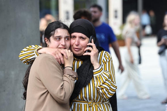 Hai người phụ nữ sơ tán khỏi trung tâm thương mại Fields ngày 3/7. Ảnh: AFP